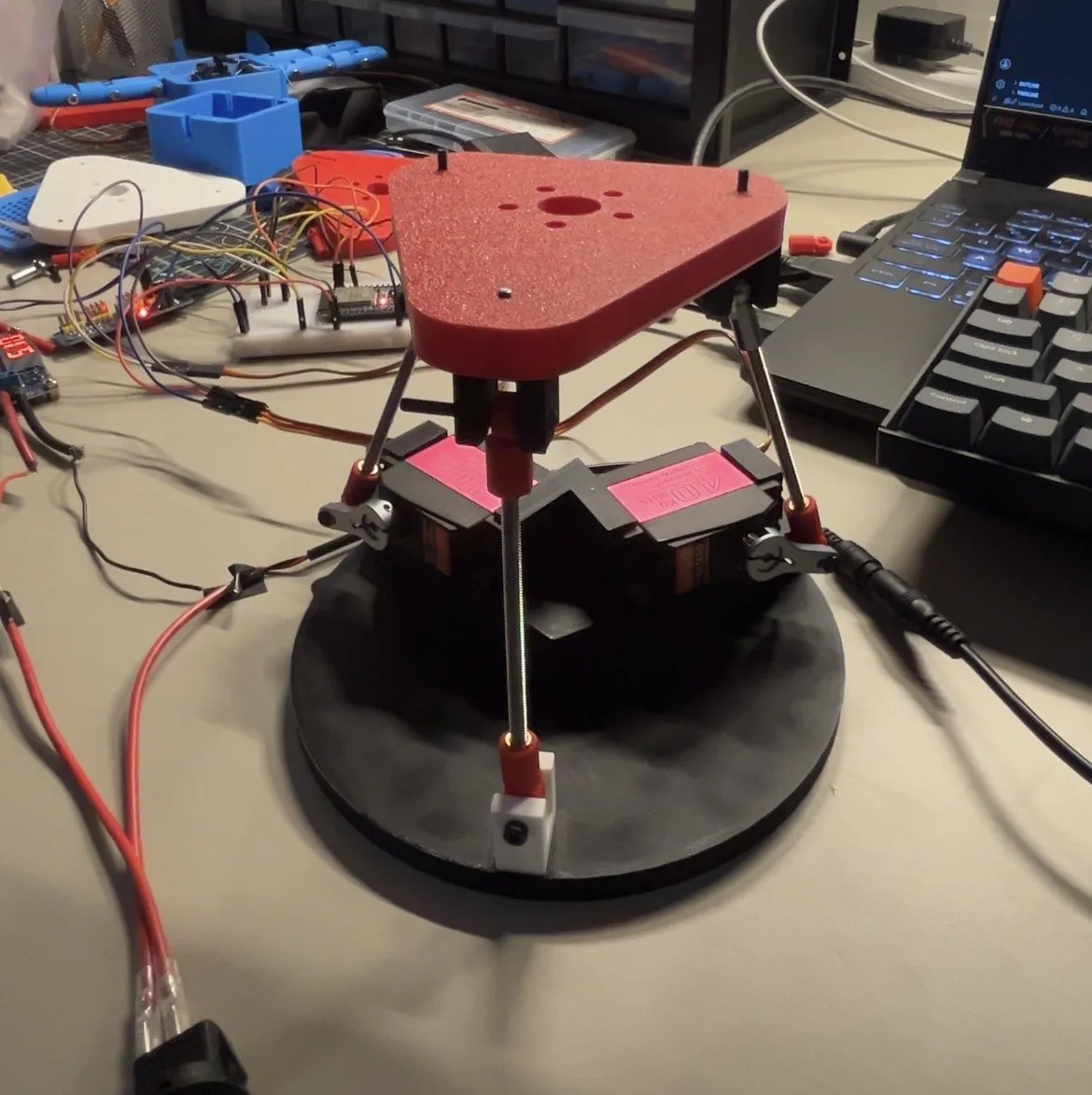 Bench prototype of the neck with two servos and a red triangular top plate